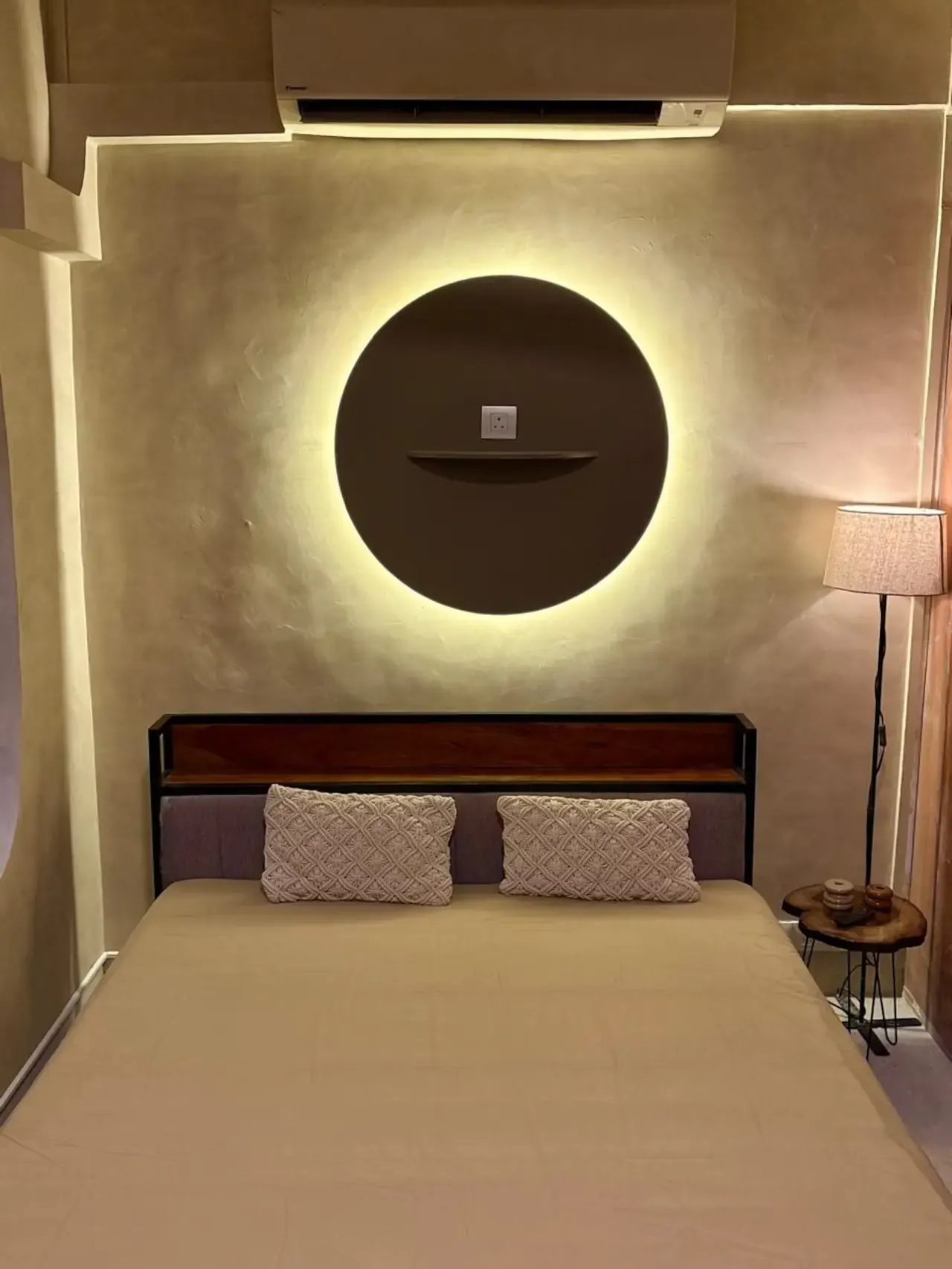 Double bed beneath a round backlit panel