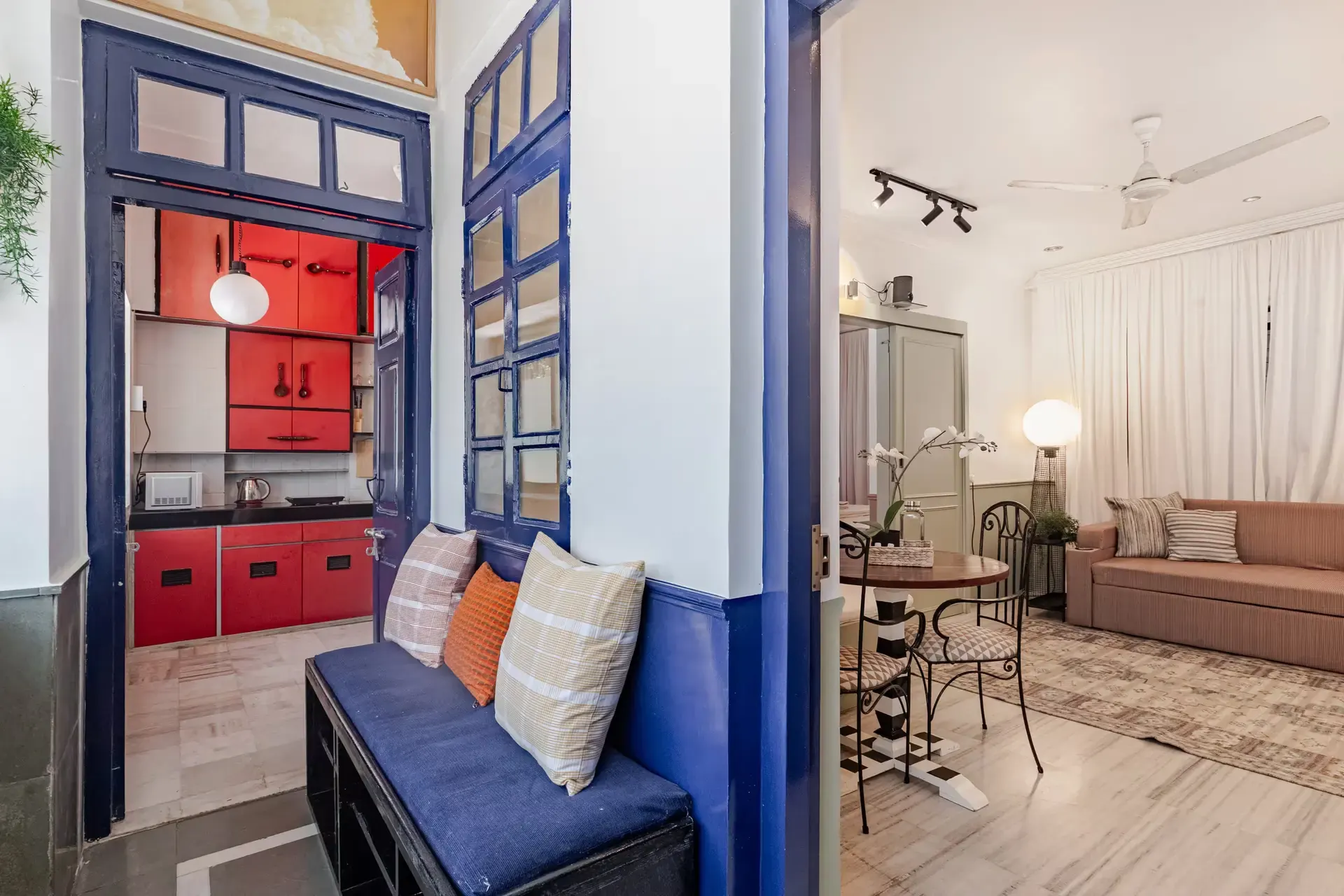 Blue-framed window opening from the entrance bench into the living room