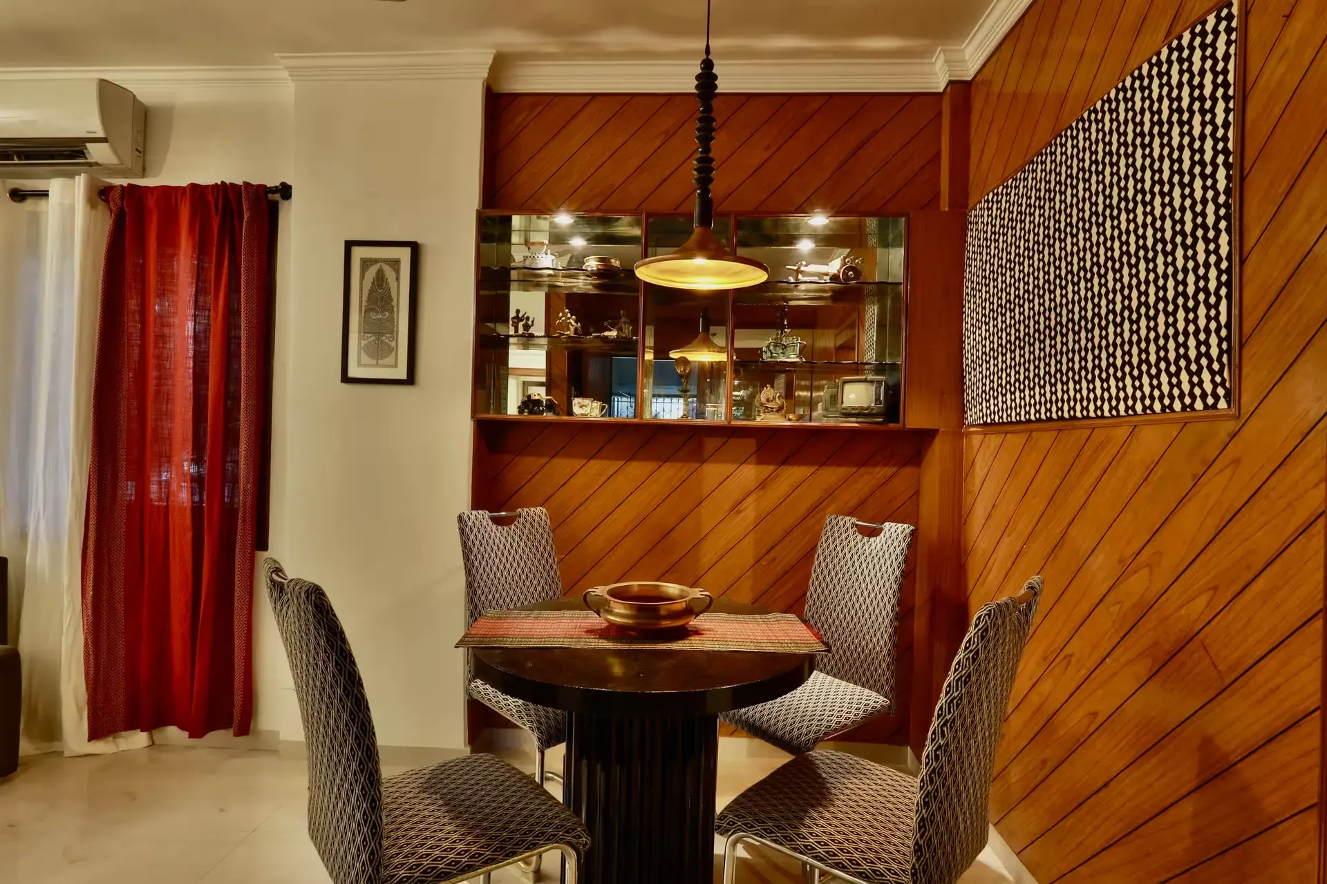 Dining table with patterned chairs beside a timber-panelled nook