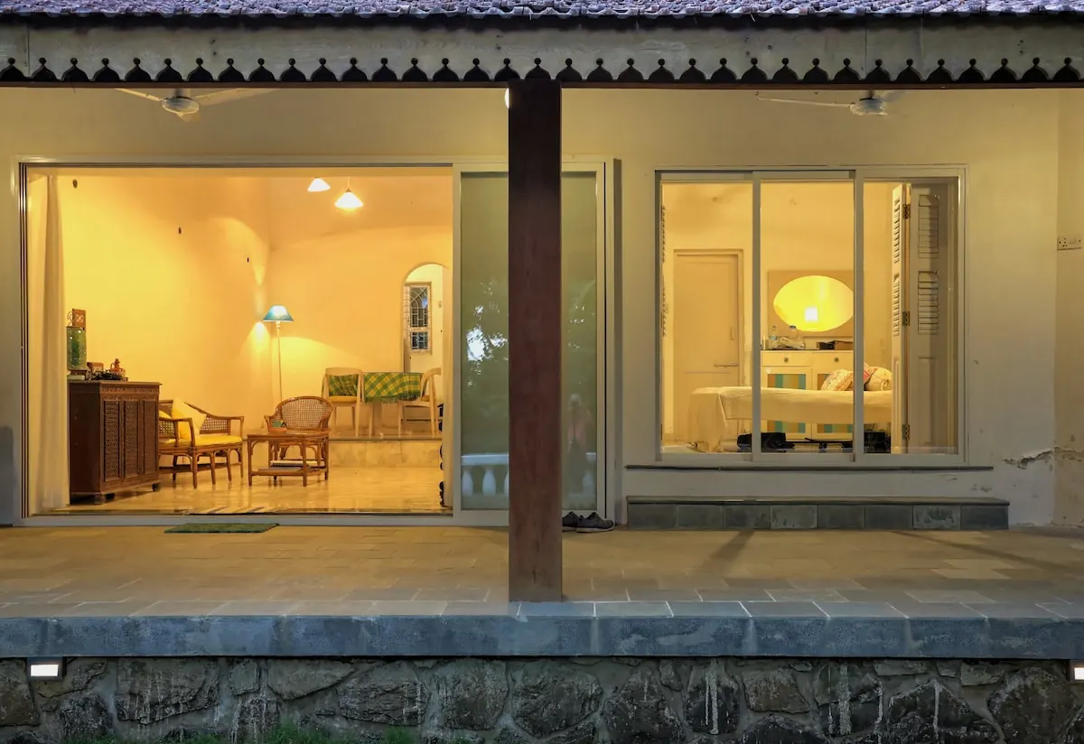 La Mer's sliding doors lit up at dusk, showing the living room and a bedroom