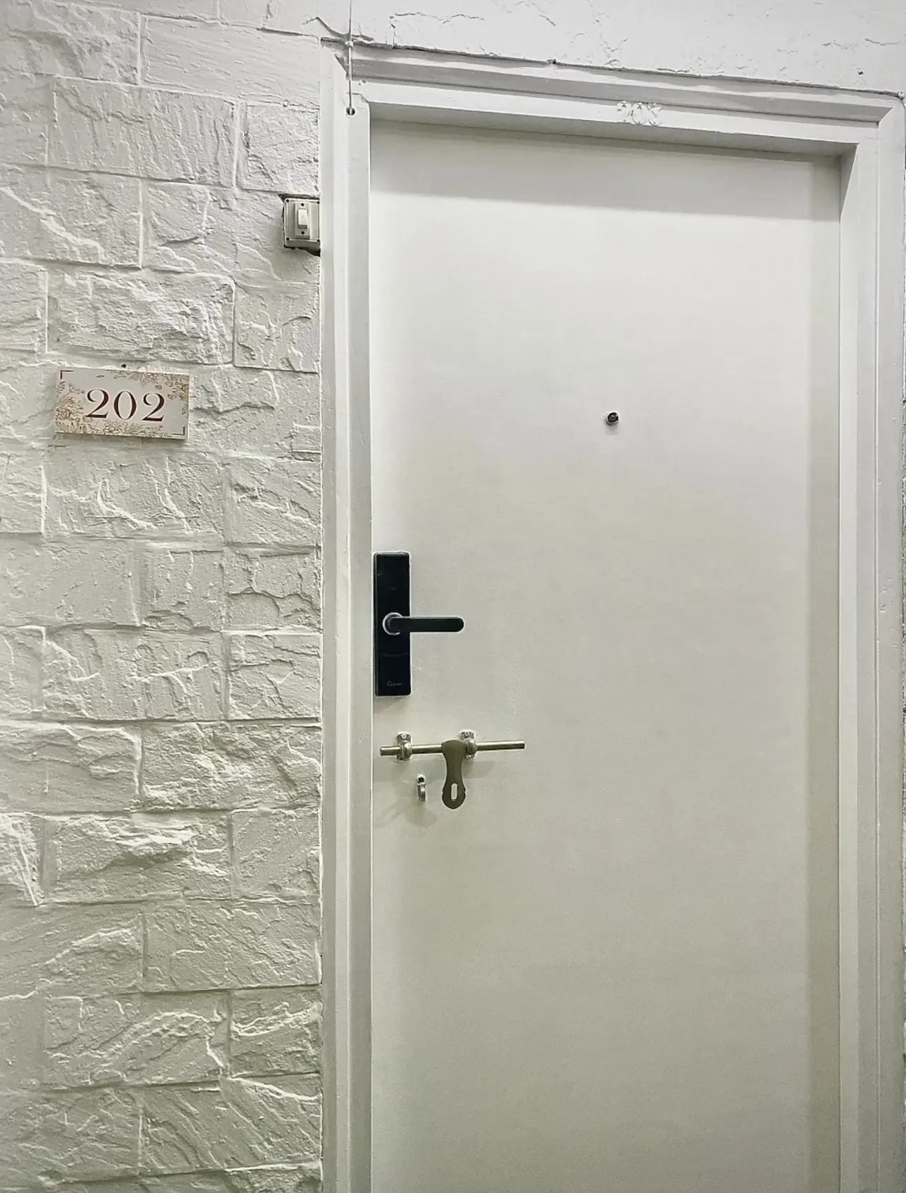 The studio's plain white entrance door with a digital lock